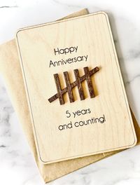 Our personalized 5th year wooden anniversary card is the perfect way to celebrate a couples special day! Year 5's traditional anniversary gift is wood! option to customize front of card option to add personal message on the back Each card is laser engraved on natural baltic birch measuring 4.75 x 6.75 inches with 5 x 7inch kraft envelope included - option to add additional 2 inch acrylic stand for permanent display.   CARD FITS SNUGGLY INTO ACRYLIC STAND. BEST TO PLACE STAND ON HARD SURFACE AND