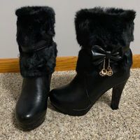 These Black Furry Boots Have Never Been Worn! They Have A 4 Inch Heel And Fur Detail On The Top All The Way Down To About Halfway On The Boot. They Also Have A Faux Leather Strap Around The Halfway Point Of The Fur And A Faux Leather Bow On This Strap. They Also Have Dangling Metallic Cubes Hanging Off The Bows. They Have A Side Zipper To Take On And Off. Where The Fur Is Not The Boots Are Faux Leather.