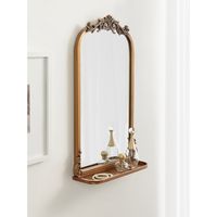 The Arendahl wall mirror brings a brilliant and decadent accent to any traditional home design. This wall mirror features a baroque-inspired design, with a resin garland crown cascading down an arched iron frame. The stunning antique gold finish brings it together as a vintage piece to display anywhere in your home. This version of the Arendahl features a functional shelf to place some small decor accents or necessary household items. Due to its hand-finished craftsmanship, each piece may vary i