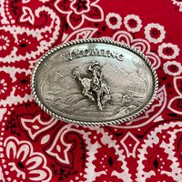 Montana Silversmith WYOMING belt buckle. Made for 2” belt. Mountain scene with Wyoming bucking horse. Engraved back. Gift box.