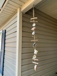 "Add a touch of the beach to your coastal, rustic, farmhouse, or bohemian home decor with this handmade seashell hanging, designed using a variety of seashells, driftwood, and wooden beads.  Seashell wind chime measures 35\" long. Hang seashell home decor inside or in your outside porch, patio, or garden area.  Free Shipping"