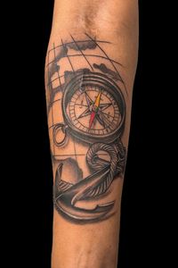 Black and grey compass and anchor on a nautical map