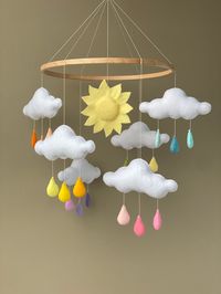 Rainbow rain cloud baby mobile for the sunshine nursery. This mobile is well suited for the baby girl or boy and will be great for a new baby shower gift and the perfect decor for the baby rainbow nursery. Individual design is possible. Just ask me if you want to change any detail of the mobile. 🌦BABY MOBILE INCLUDES  - 6 clouds with rainbow drops and the sun  - the wooden hanger with toys Additional you can add to your order crib mobile hanger with music box (see link below) https://www.etsy.c