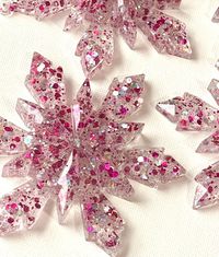 Add a touch of sparkle to your holiday decor with this handmade resin snowflake ornament. Each ornament is crafted with a beautiful blend of magenta and iridescent glitter suspended in clear resin, creating a dazzling effect that catches the light. Perfect for decorating your tree or gifting to loved ones, these unique snowflakes bring a festive, whimsical charm to any space.