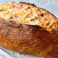 Cheesy Baked Dip ~ 8 oz. Sour Cream, 8 oz. Cream Cheese, 16 oz. Cheddar Cheese, grated (sharp or mild), 4 oz. Chopped Green Chilies, Green Onion (suit your own taste), 1 c. Chopped Ham, ½ pound Chopped Bacon, 1 round Bread Loaf, hollowed out.