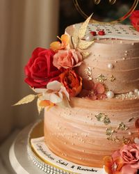 This cake was designed completely by the client❤ Made this two tier engagement cake sometime back in peachy shades, with orange and red touch to enhance the look. Adorned with flowers in different shades.