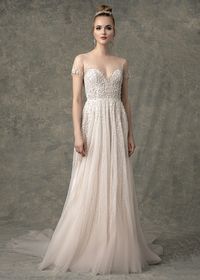 The Serena wedding dress has a short sleeve illusion neckline with sweetheart lining, beaded bodice and A-line skirt with whimsical vine like beading throughout and buttons down the center back. #wedding #weddingdress #weddingideas #weddingplanning #weddingdressstyles #shortsleeveweddingdress #shortsleevedweddingdress #weddingdressinspiration #weddinginspiration