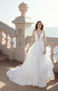 Layered light tulle ballgown with horsehair hem, beaded lace deep-v neckline and back. Available off the rack at Silk Bridal Studio.