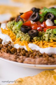 This Vegan 7-Layer Dip is going to find its way to your heart because it's so easy to throw together and no one will guess it's vegan!