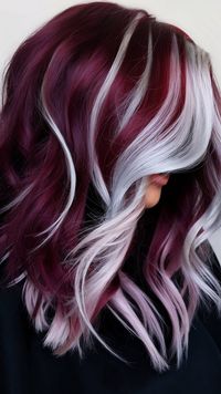 Embrace your fierce side with this fabulous hair transformation! The blend of vibrant burgundy and cool silver highlights creates a unique and eye-catching look. This hairstyle is perfect for anyone looking to express their individuality with style. #hairstyle #haircolor #haircut #wavyhair #hairinspo #burgundy