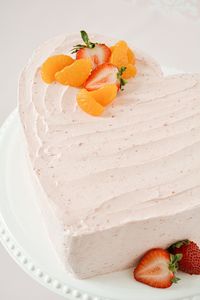 A pretty heart shaped layer cake made without a heart cake pan! Learn how to make a beautiful and delicious strawberry orange heart cake, perfect for Valentine's Day, Mother's Day, anniversaries and birthdays.