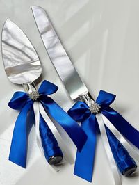 "Cake Serving Set Royal Blue Cake Servers and Knifes, Cake Knife Set, Cake Server Blue, Birthday Cake Server, Royal Blue Wedding Accessories This beautiful and customizable wedding accessories set is perfect for your special day!  Made with high-quality satin, lace, ribbons, and brooch. You can select your primary color (fabric color) from our drop-down menu, and choose your accessories in the drop-down menu as well.  If you require a different combination of accessories, simply send us a message, and we'll respond promptly. Our \"Whole Set as 1st Pic\" option includes a Ring Bearer Pillow, Flower Girl Basket and Guest Book with Pen. Our \"Whole Set as 2nd Pic\" option includes a Ring Bearer Pillow, Flower Girl Basket, Guest Book with Pen and Cake Serving Set. Please note that the Unity Ca