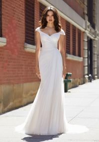 Fitted ruched tulle bridal gown with off the shoulder neckline and draped tulle detail on the side. Available off the rack at Silk Bridal Studio.