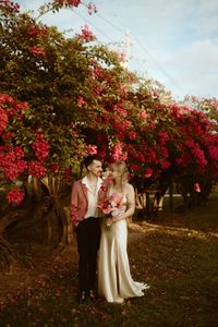 Beautiful wedding shot captured in front of one of the many blooming Bougainvillea trees on site. There are many amazing spaces to get great timeless photos at the Edison and Ford Winter Estates. There are also spots on site for a gorgeous ceremony or reception surrounded by blooms and greenery. Photo by Brooke Anne Photography.