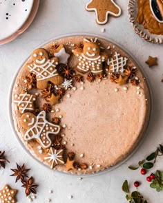 an overhead view of a cake with ginger cookies and other holiday decorations on it,