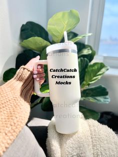 a person holding a white coffee cup with the words catchcatch creations mocks on it