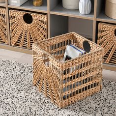 two wicker baskets sitting on top of a rug next to a book shelf filled with books