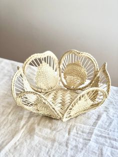 two wicker baskets sitting on top of a white table cloth covered bedding area