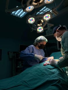 two surgeons performing surgery on a patient in an operating room with lights above the bed