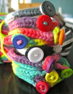 a close up of a knitted hat with buttons and yarns on the top