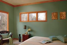 a bedroom with green walls and two windows