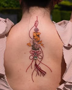 the back of a woman's neck with flowers on it