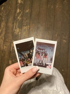 two polaroids held up in front of a wooden wall