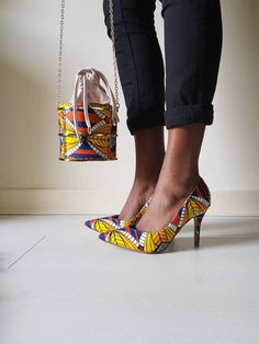 Comfortable Almond toe courts in this fabulous eye catching Ankara print complete with matching bag. Available in European sizes 36-41  **PLEASE NOTE THIS STYLE OF BAG HAS OFFICIALLY CHANGED. THE CAGED BAG IS STILL AVAILABLE BUT REQUIRES A LONGER WAITING TIME DUE TO WHERE IT IS SOURCED FROM. THANK YOU African Print Shoes, Cage Bag, African Shoes, Handcrafted Handbags, African Accessories, Ankara Print, Bag Set, Beautiful Shoes, Womens Heels