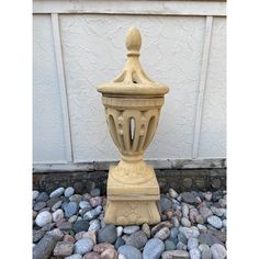 a stone urn sitting on top of a pile of rocks next to a building