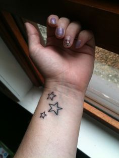 a woman's wrist with three stars on it