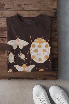 Thanks for stopping by! Moths and Ladybirds  T-shirt Printed on a super soft, cotton tee Dispatched in 5 working days or sooner Unisex Free UK delivery Material: 100% ringspun cotton. Chest (to fit): S  34/36   M  38   L  40/42   XL  44/46   XXL  48/50 ECO-FRIENDLY Each garment is made to order, reducing extra material and energy that would be otherwise wasted We use DTG printing process which is easier on the environment than screen-printing Our ink is bright and also eco-friendly. Do not tumble dry Wash at 30 degrees c inside out Do not iron over print Halloween Goblincore T-shirt With Graphic Print, Bleached Moth Shirt, Tshirt Grunge, Cottagecore Printed Cotton T-shirt, Fairycore Clothing, Cute Cotton T-shirt With Mushroom Print, Clothing Cottagecore, Moth T Shirt, Indie Clothing