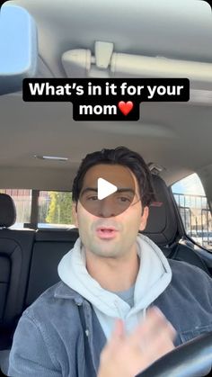 a man driving a car with the words what's in it for your mom