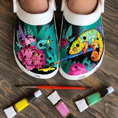 a child's feet with painted shoes and crayons