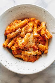 a white bowl filled with pasta and sauce