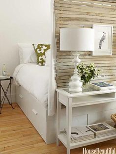 a bedroom with white bedding and wooden slats on the headboard, along with a lamp