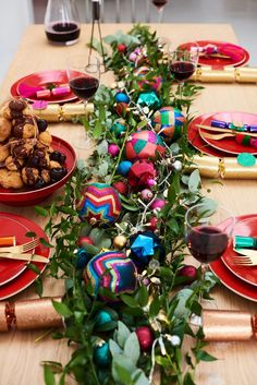 the table is set with red plates, silverware and colorful decorations on it's edges