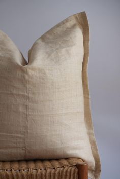 a beige pillow sitting on top of a wooden chair