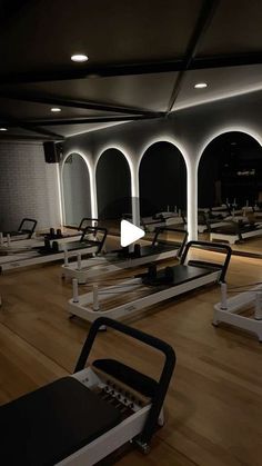 an empty gym with rows of treadmills and exercise equipment in the foreground