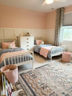 a bedroom with two twin beds and a rug on the floor in front of it