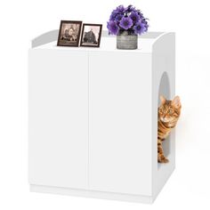 a cat hiding behind a white cabinet with purple flowers and pictures on the top shelf