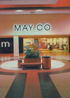 the entrance to a mall with a planter in it's center aisle and sign that says may co