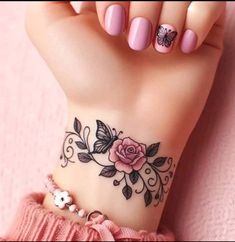 a woman's wrist tattoo with pink flowers and butterflies on her left hand,