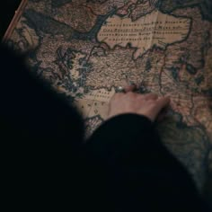 a person is looking at a map on the floor with their hand resting on it