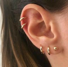 a close up of a person's ear with three different types of piercings