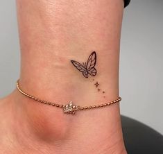 a small tattoo on the ankle of a woman's foot with a butterfly and stars