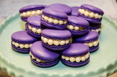 purple macaroons with white pearls are on a plate