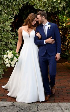 a bride and groom are standing in front of some greenery at their wedding day