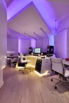 an office with purple lighting and white furniture