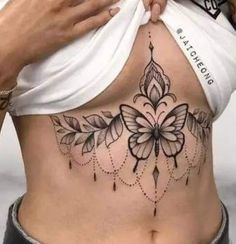 a woman's stomach with tattoos on it and flowers in the bottom part of her belly