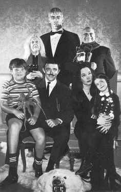 an old black and white photo of a family posing for a group shot with a dog